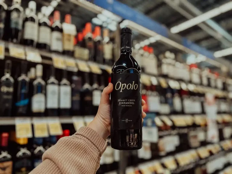 Hand holding a bottle of Opolo Summit Creek Zinfandel in a grocery store wine aisle