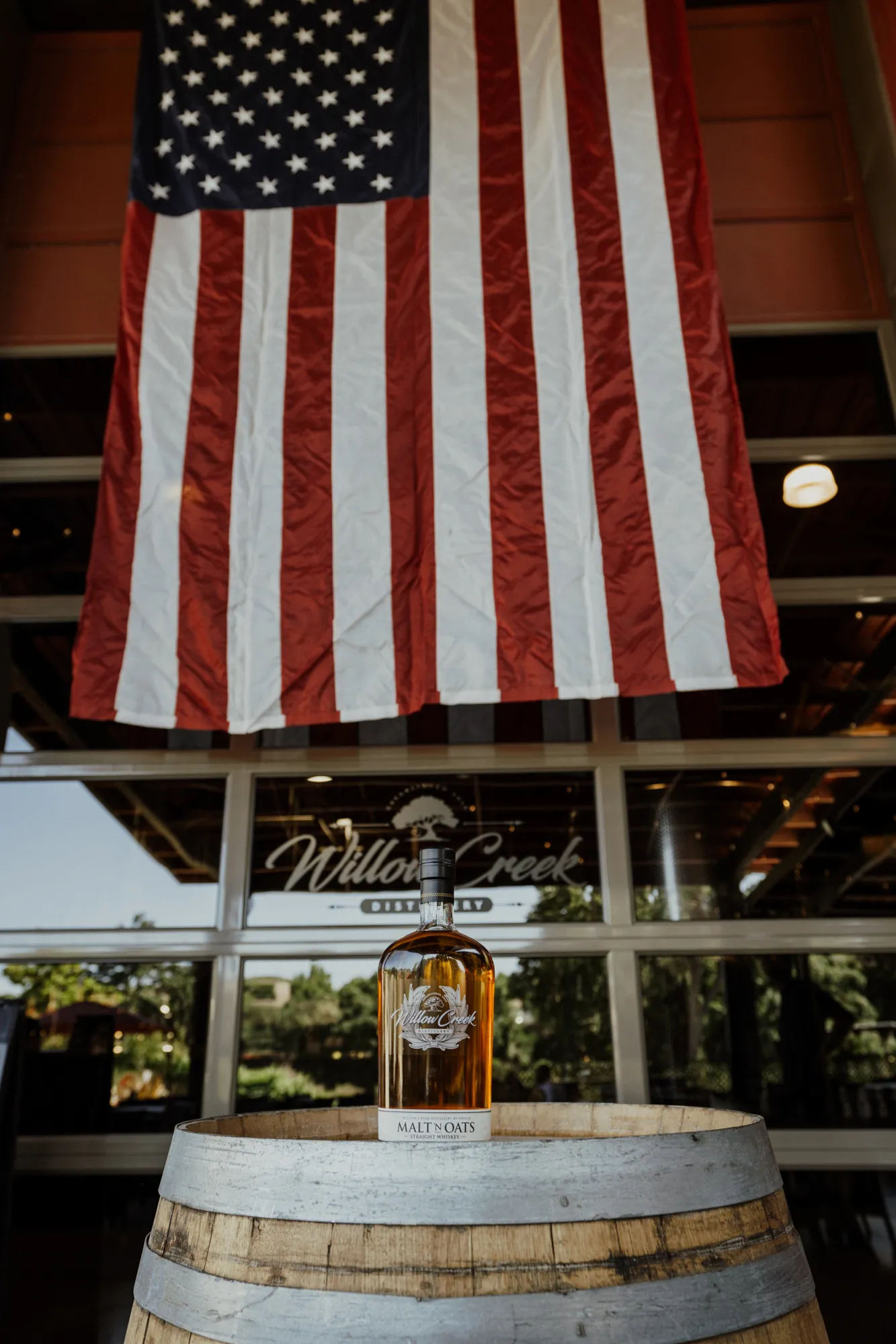 American flag and a bottle of Willow Creek Distillery malt liquor